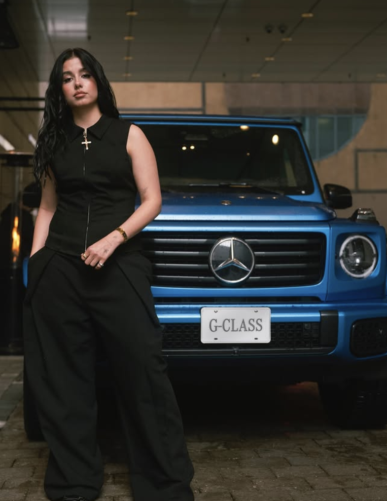 Artist standing in front of a blue Mercedes-Benz G-Class